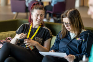 Two youth workers sit together during a Youth Scotland event