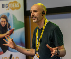 A portrait photo of Kevin Turner giving a talk at an event