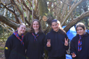 A group of young people pose smiling next to their newly-built den