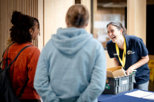 A group of three youth workers laugh together at an event