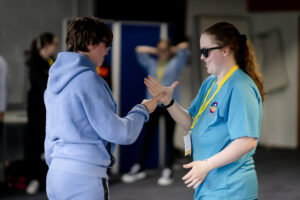 Two young people shake hands.