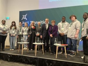 Young Advisors attending the Just Transition summit pose with politicians