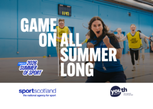 A young person slides towards the camera on their knees, celebrating scoring, while team mates give chase. The headline reads: Game On | All Summer Long