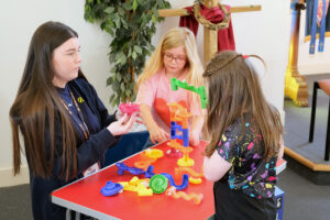 A young leader helps young people in their activities at youth club
